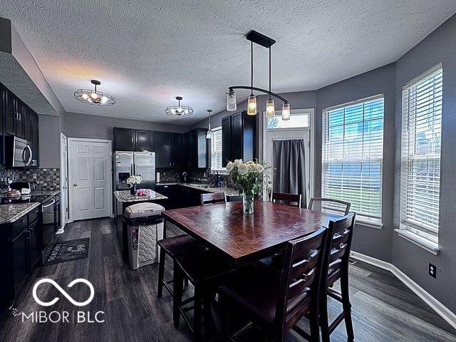 6155 W Bayfront, Mccordsville, IN 46055 - dining area featuring dark wood-type flooring, a textured ceiling, and baseboards