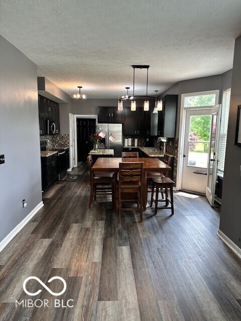 6155 W Bayfront, Mccordsville, IN 46055 - dining area with dark wood-style flooring, a textured ceiling, baseboards, and a chandelier
