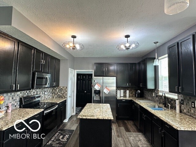 6155 W Bayfront, Mccordsville, IN 46055 - kitchen featuring stainless steel appliances, a sink, dark wood-style floors, a center island, and a textured ceiling