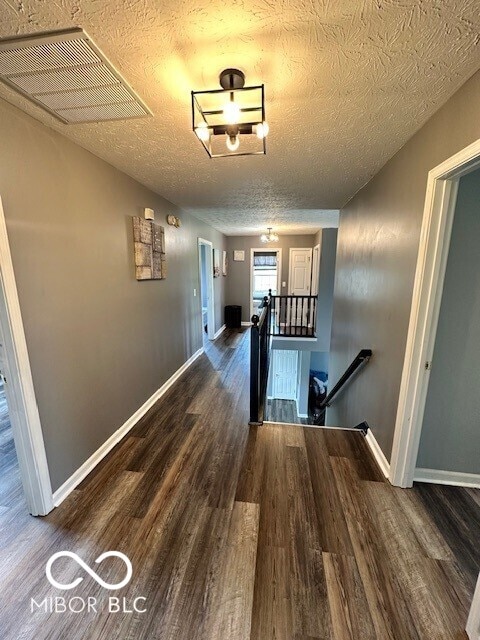 6155 W Bayfront, Mccordsville, IN 46055 - corridor with an upstairs landing, wood finished floors, baseboards, and a textured ceiling