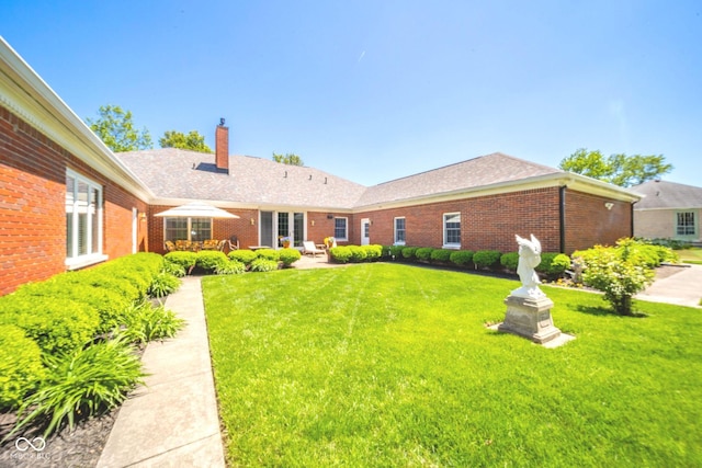 1105 Deer Creek Dr, Anderson, IN 46011 - back of property with brick siding, a chimney, a yard, and a patio