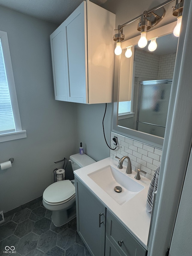 3641 S Rogers St, Bloomington, IN 47403 - full bathroom featuring toilet, a shower stall, vanity, decorative backsplash, and tile patterned flooring