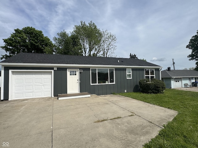 3641 S Rogers St, Bloomington, IN 47403 - single story home featuring board and batten siding, a front lawn, concrete driveway, a garage, and a shingled roof