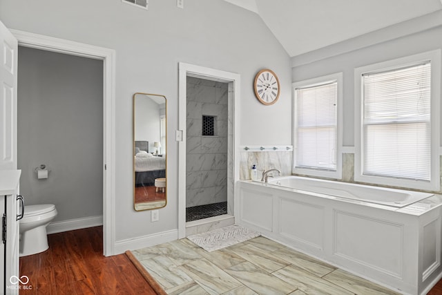 full bathroom featuring a bath, vaulted ceiling, a stall shower, toilet, and marble finish flooring