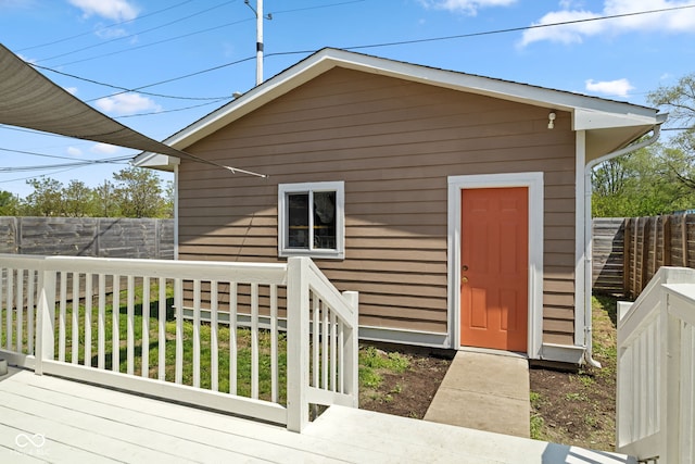 view of outdoor structure with fence and an outbuilding
