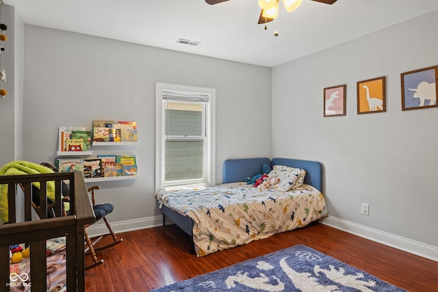 bedroom featuring baseboards, wood finished floors, and a ceiling fan