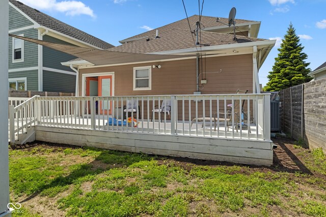 rear view of property with a deck, a shingled roof, a fenced backyard, and central air condition unit