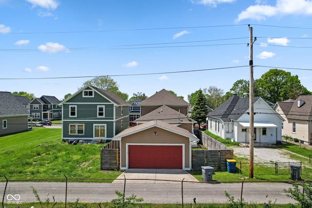 view of front of property with a residential view, a detached garage, and driveway