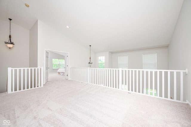 carpeted empty room with lofted ceiling and baseboards