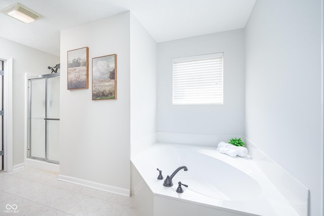 bathroom with a shower stall, a bath, and baseboards