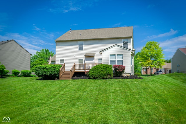 rear view of house with a deck and a lawn
