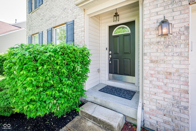 view of exterior entry featuring brick siding