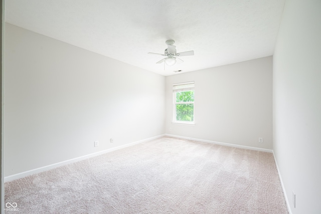 spare room with baseboards, carpet floors, and a ceiling fan