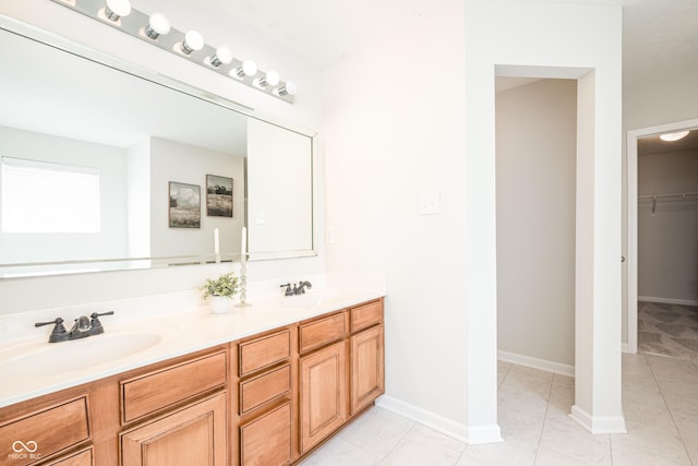 full bath with tile patterned floors, double vanity, baseboards, and a spacious closet