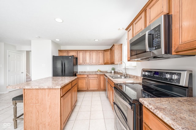 kitchen featuring appliances with stainless steel finishes, a sink, a center island, light tile patterned floors, and recessed lighting