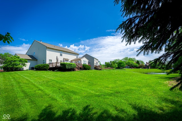 view of green lawn with a deck