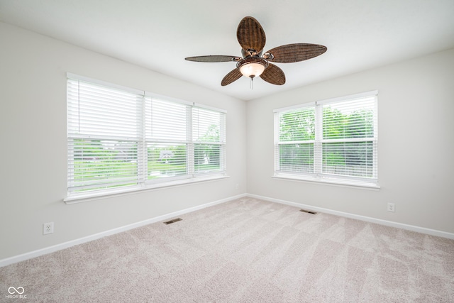 carpeted spare room with baseboards and ceiling fan