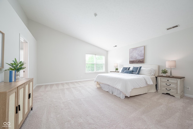bedroom with vaulted ceiling, light carpet, and baseboards