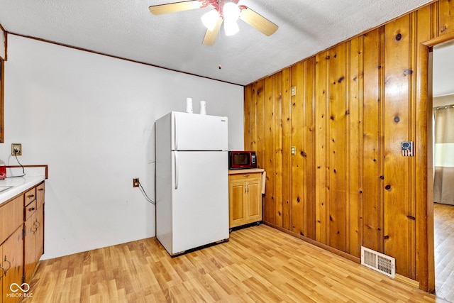 518 N Carr Rd, Plainfield, IN 46168 - kitchen with freestanding refrigerator, light wood finished floors, a ceiling fan, light countertops, and brown cabinets