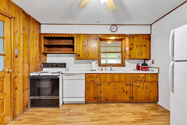 518 N Carr Rd, Plainfield, IN 46168 - kitchen with white appliances, a sink, brown cabinets, light wood-type flooring, and wood walls