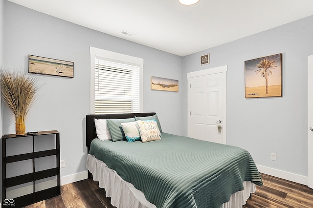 bedroom with baseboards and wood finished floors