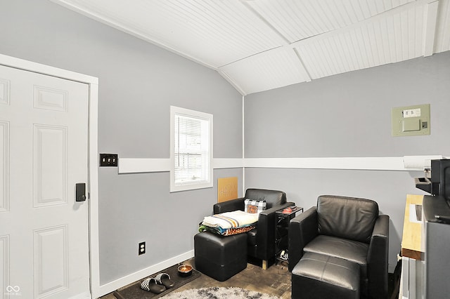 living area with vaulted ceiling and baseboards
