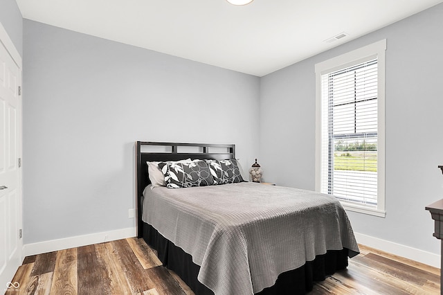 bedroom with baseboards and wood finished floors