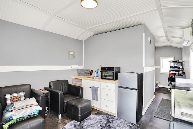 office space with dark wood-style floors, a sink, vaulted ceiling, baseboards, and an AC wall unit