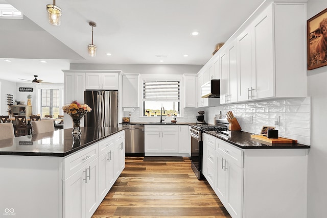 kitchen featuring appliances with stainless steel finishes, dark countertops, recessed lighting, a ceiling fan, and tasteful backsplash