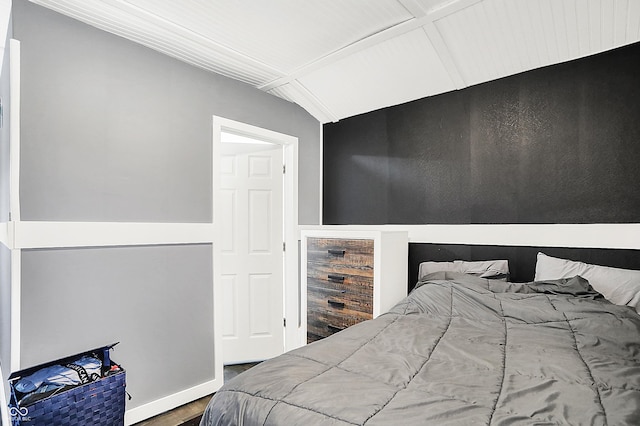 bedroom featuring wood finished floors and vaulted ceiling