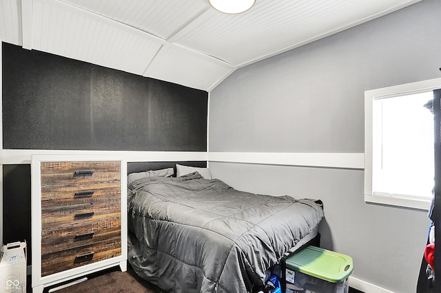 carpeted bedroom with lofted ceiling