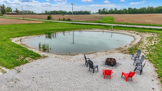 view of community featuring an outdoor fire pit, a lawn, and a water view