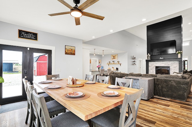 dining room with light wood-style floors, ceiling fan, a fireplace, french doors, and recessed lighting