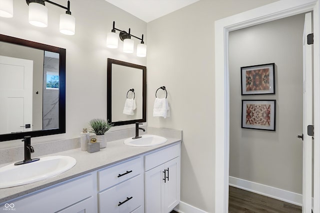 1429 Deloss St, Indianapolis, IN 46201 - bathroom featuring double vanity, wood finished floors, and baseboards