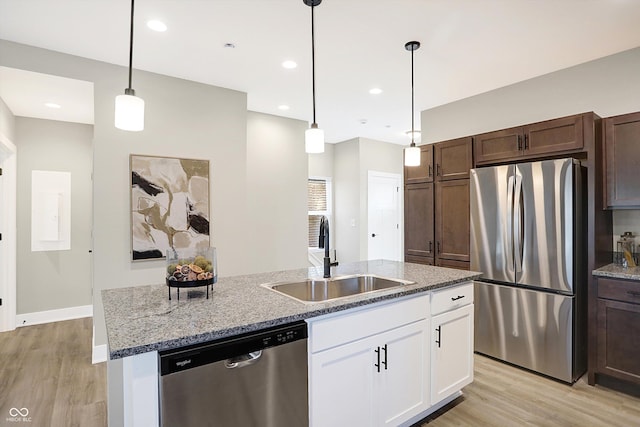 1429 Deloss St, Indianapolis, IN 46201 - kitchen featuring stainless steel appliances, a sink, light wood finished floors, an island with sink, and white cabinets