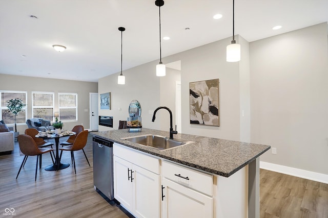 1429 Deloss St, Indianapolis, IN 46201 - kitchen featuring a sink, dishwasher, open floor plan, light wood-style flooring, and an island with sink