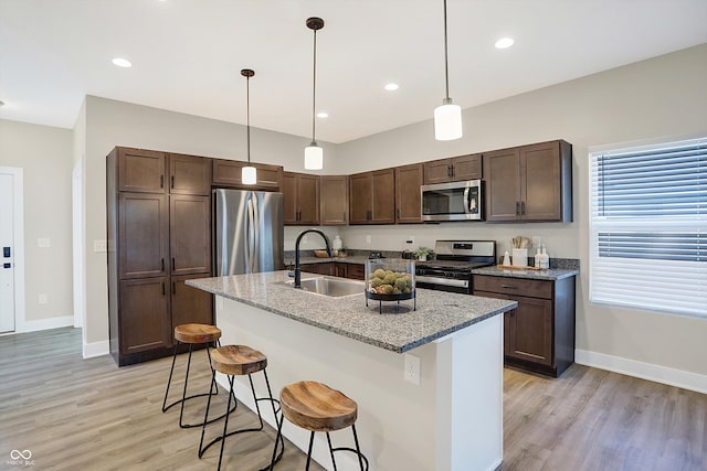 1429 Deloss St, Indianapolis, IN 46201 - kitchen with stainless steel appliances, a sink, baseboards, light wood-type flooring, and recessed lighting