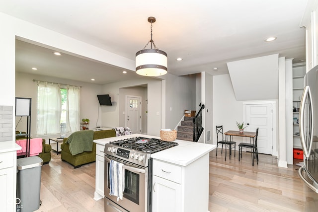 1043 N Beville Ave, Indianapolis, IN 46201 - kitchen with appliances with stainless steel finishes, white cabinetry, light wood-style flooring, open floor plan, and light countertops