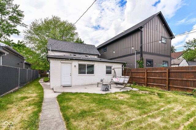1043 N Beville Ave, Indianapolis, IN 46201 - rear view of house with a patio area, board and batten siding, roof with shingles, and brick siding
