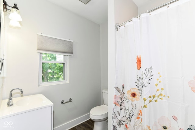 1043 N Beville Ave, Indianapolis, IN 46201 - full bath with wood finished floors, toilet, vanity, baseboards, and a shower with shower curtain