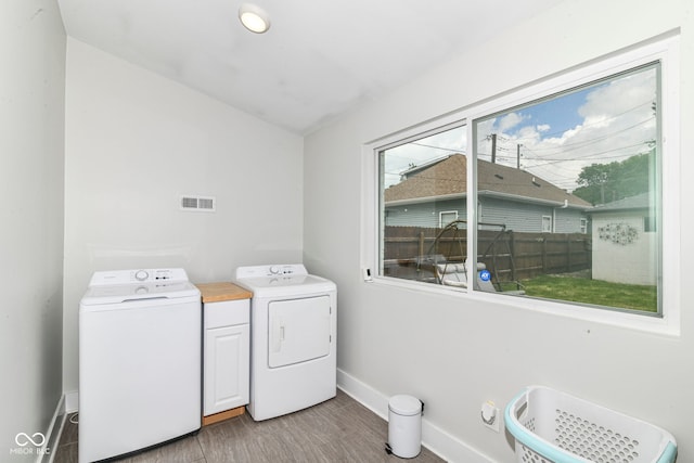 1043 N Beville Ave, Indianapolis, IN 46201 - laundry room with baseboards, washing machine and clothes dryer, cabinet space, and wood finished floors