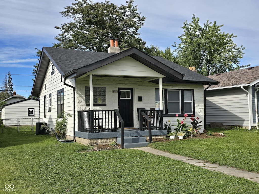 3848 Spann Ave, Indianapolis, IN 46203 - bungalow-style house featuring a shingled roof, a chimney, covered porch, and central AC unit