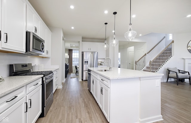 7239 Barrett Dr, Brownsburg, IN 46112 - kitchen with appliances with stainless steel finishes, a sink, light wood-type flooring, baseboards, and recessed lighting