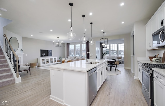 7239 Barrett Dr, Brownsburg, IN 46112 - kitchen with appliances with stainless steel finishes, a sink, open floor plan, a chandelier, and recessed lighting