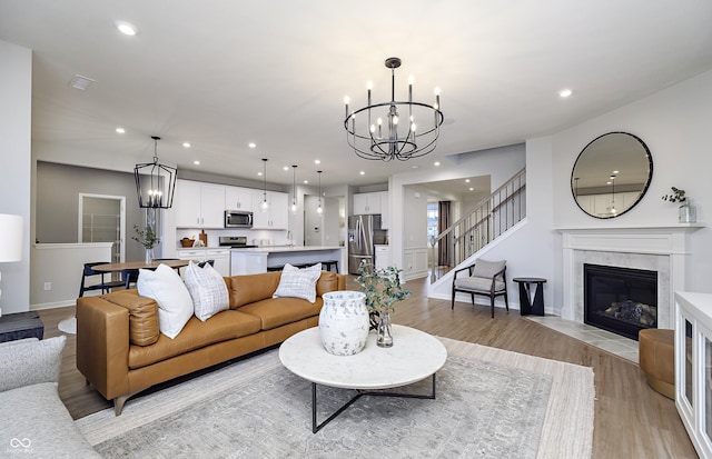 7239 Barrett Dr, Brownsburg, IN 46112 - living room featuring a chandelier, light wood-style floors, recessed lighting, a fireplace, and baseboards