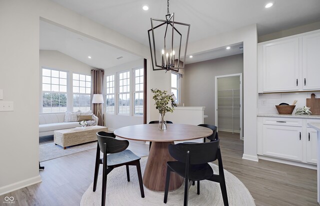 7239 Barrett Dr, Brownsburg, IN 46112 - dining room with light wood-style flooring, a chandelier, recessed lighting, baseboards, and lofted ceiling