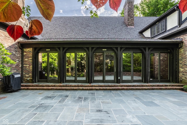 7406 N Washington Blvd, Indianapolis, IN 46240 - view of exterior entry with french doors, a patio, brick siding, and a chimney