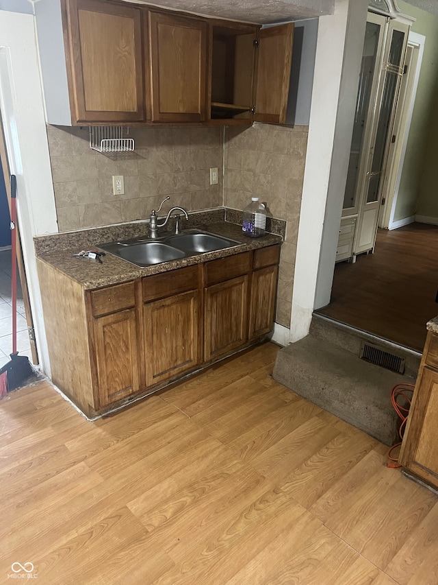 2146 Gent Ave, Indianapolis, IN 46202 - kitchen with a sink, dark countertops, and light wood-type flooring