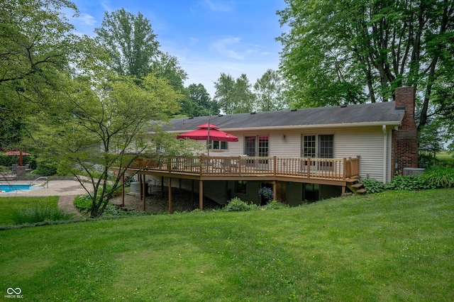 17216 W Hunnicut Rd, Cambridge City, IN 47327 - back of property featuring a deck, a lawn, a chimney, an outdoor pool, and a patio