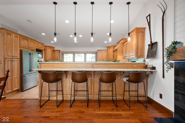 17216 W Hunnicut Rd, Cambridge City, IN 47327 - kitchen with high end refrigerator, recessed lighting, black microwave, a peninsula, and light wood-style flooring